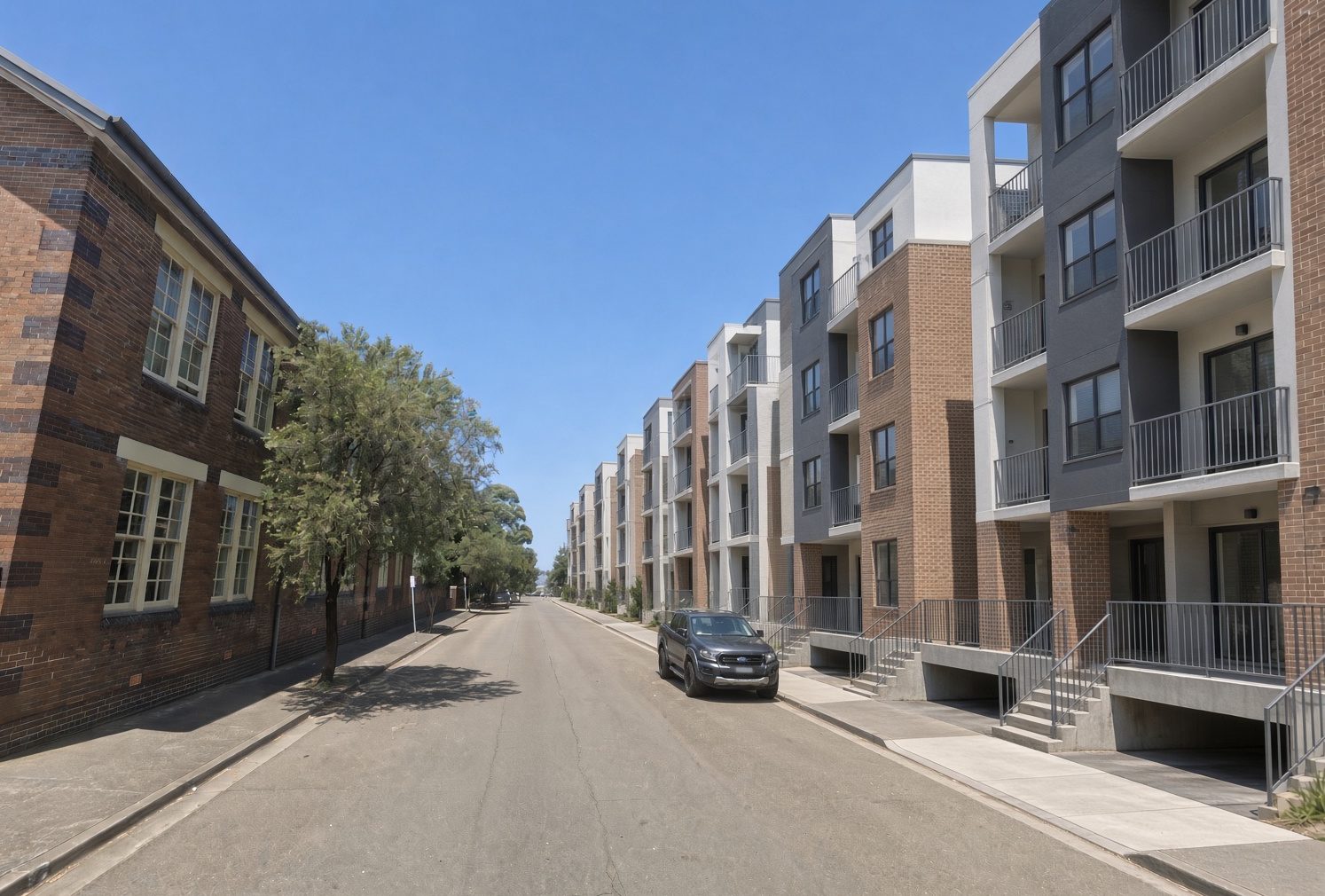 Same street with a run of new apartment buildings along the right; school building unchanged.