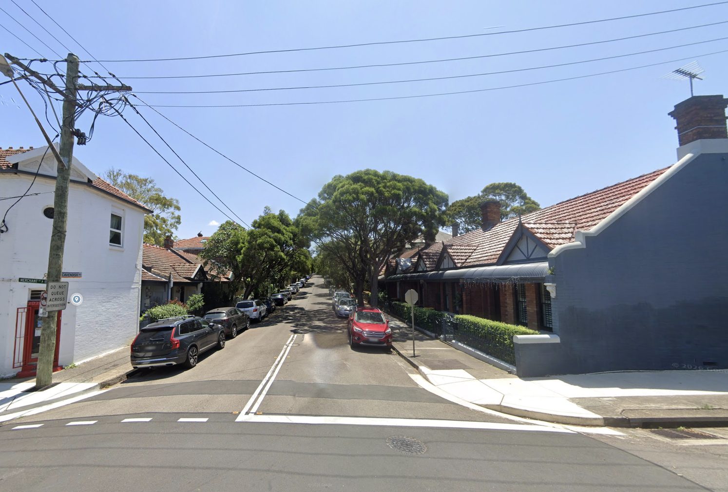 Merchant Street corner looking up Cavendish Street: white corner shop on the left, cottages on the right.