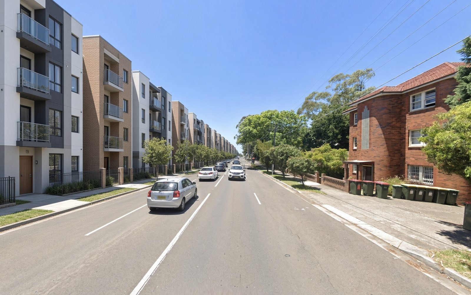 Same road with new apartment buildings replacing the houses on the left; red-brick flats kept.